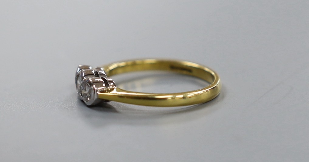 A modern 18ct gold and collet set three stone diamond set ring, size O, gross 3.8 grams